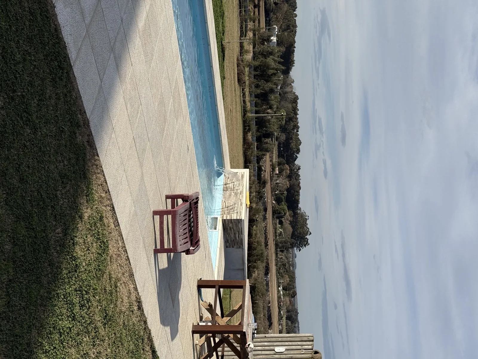 Piscina de fibra de 9.40 x 3.80 m con cascada, vereda perimetral y vista al campo, en Florida